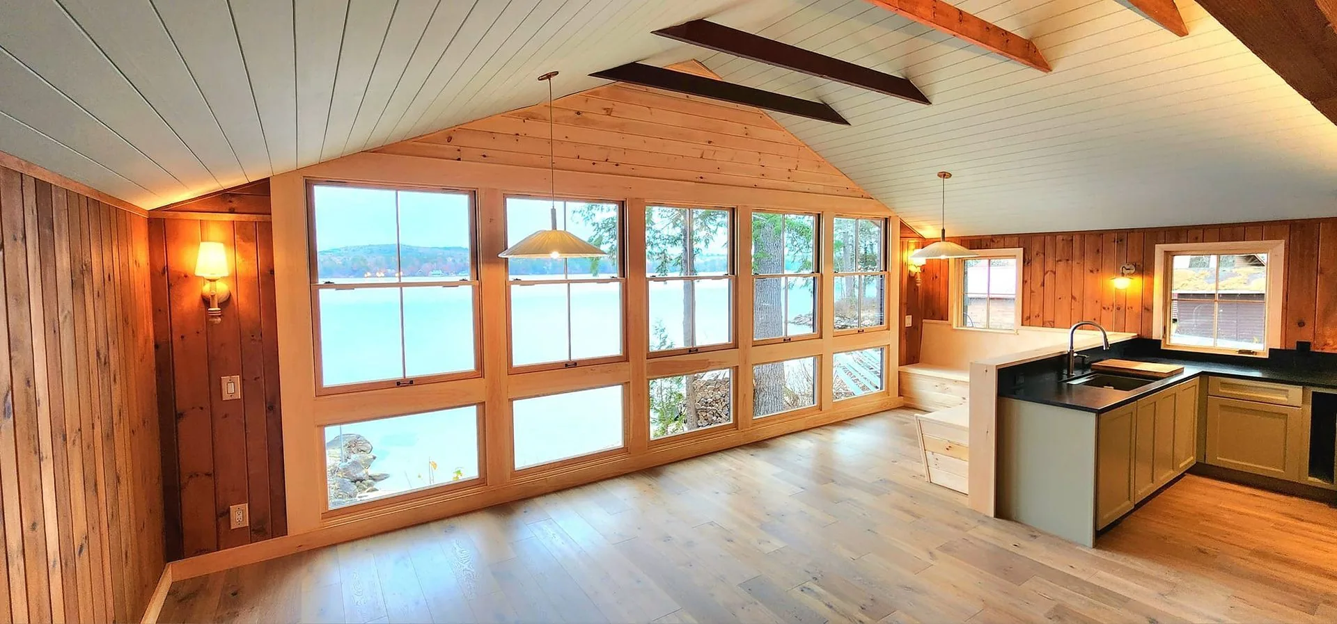 Cabin kitchen with island view, vaulted ceiling and lake windows