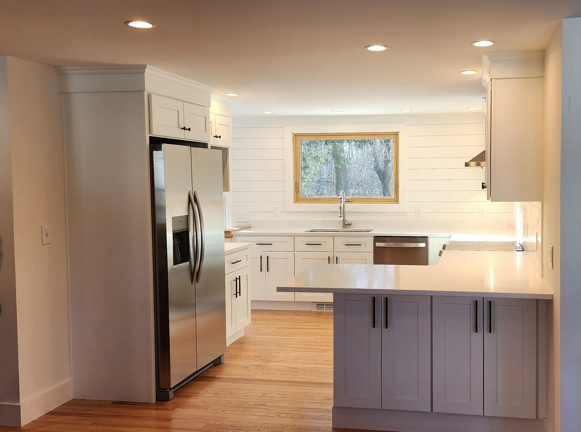 Modern white kitchen renovation with shiplap backsplash